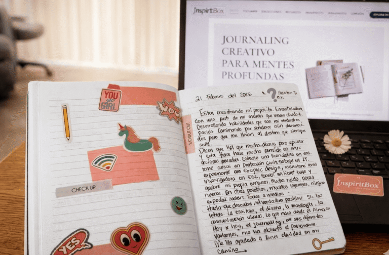 Journal real alineado con InspiritBox mostrando una práctica de journaling creativo frente a la página web.