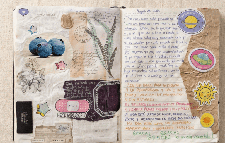 pagina de journal de manifestacion enfocada en el universo y la prosperidad con recortes de papel, stickers y arandanos